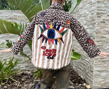 Load image into Gallery viewer, Damen Steppjacke mit Leopardenprint, beigen Streifen und kunstvollen Stickereien (buntes Auge, Lippen, Flammen, Schriftzug “Self Love Club“)